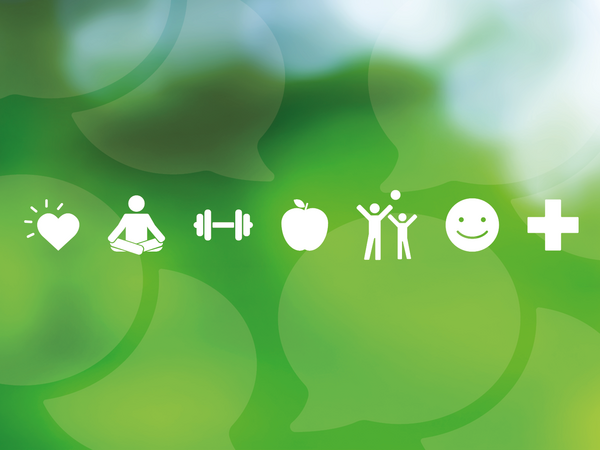 White icons sit in a row on a soft green background. The icons show a heart with lines suggesting brightness, a person meditating, a weight for physical activity, an apple, two figures celebrating, a smiling face and a medical cross.